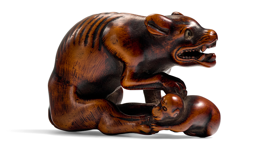 A WOOD NETSUKE OF A WILD DOG Edo period (1615-1868), 18th century. Estimate: $2,000 - $3,000