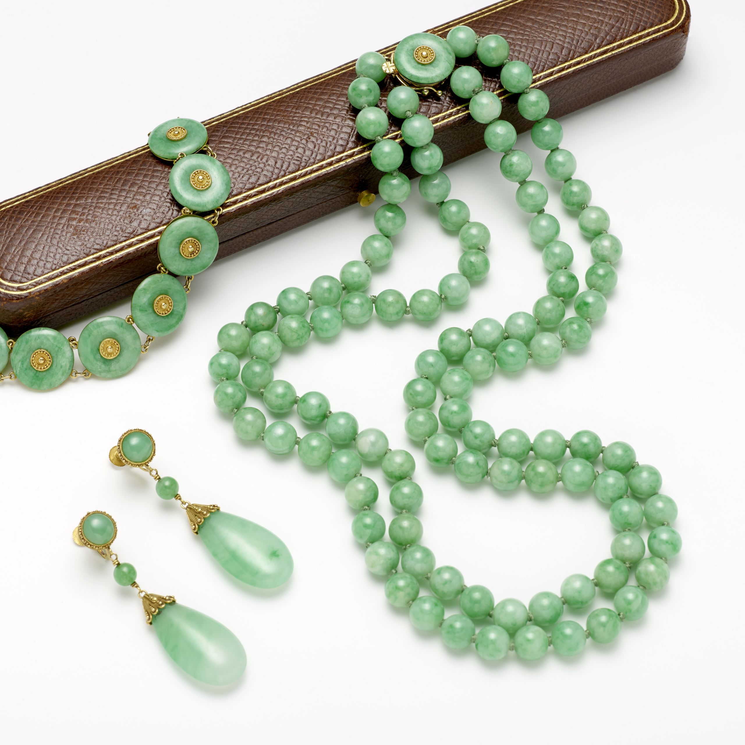 Tiffany and Co.: Gold and Jadeite Necklace, Earrings, and Bracelet, early 20th Century. Sold for US$ 37,812 inc.premium.